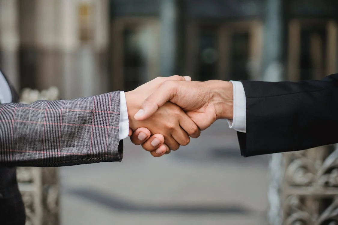Two business partners shaking hands to seal a co-founder agreement